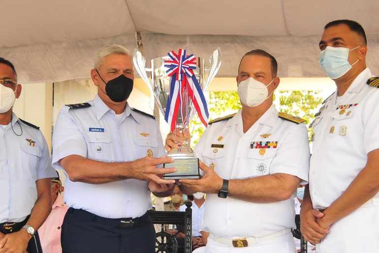 El mayor general piloto Juan Manuel Jiménez García entrega la Copa de Campeón de los Juegos de Cadetes y Guardiamarinas al comandante general de la Armada, vicealmirante Ramón Gustavo Betances Hernández. En los extremos, el mayor general Elvis Marcelino Feliz Pérez y el capitán de navío Augusto Alberto Lizardo González.